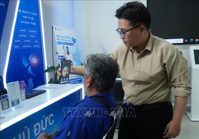 Người dân được công chức phường Thủ Đức hỗ trợ cài đặt các nền tảng để sử dụng dịch vụ công trực tuyến. Ảnh: Hữu Duyên – TTXVN