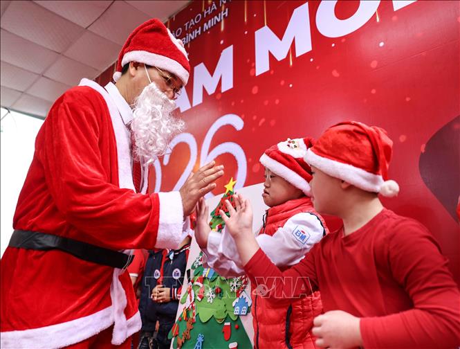 Thầy Hiệu trưởng hóa thân thành ông già Noel chúc mừng và tặng quà cho học sinh. Ảnh: Thanh Tùng - TTXVN