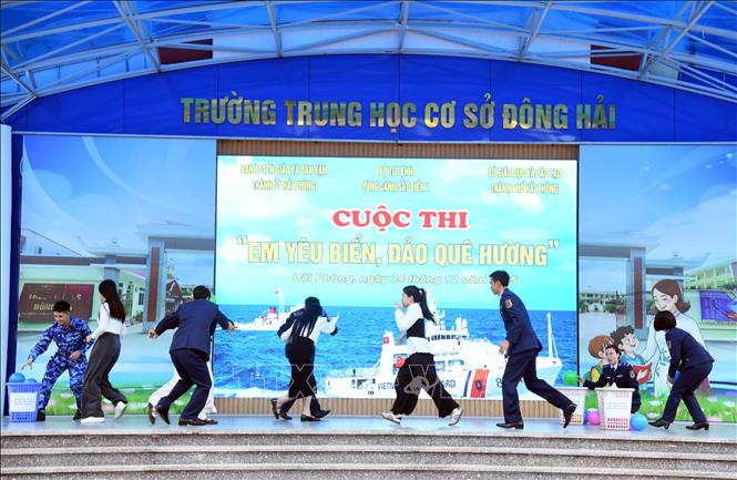 Các chiến sĩ cảnh sát biển và cô giáo tham gia phần thi giải cứu. Ảnh: Tiến Vĩnh –TTXVN