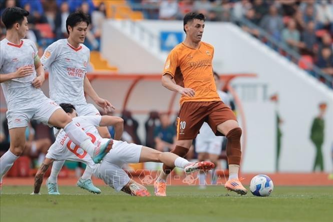 Pha tranh cướp bóng giữa cầu thủ hai đội. Ảnh: Minh Quyết - TTXVN