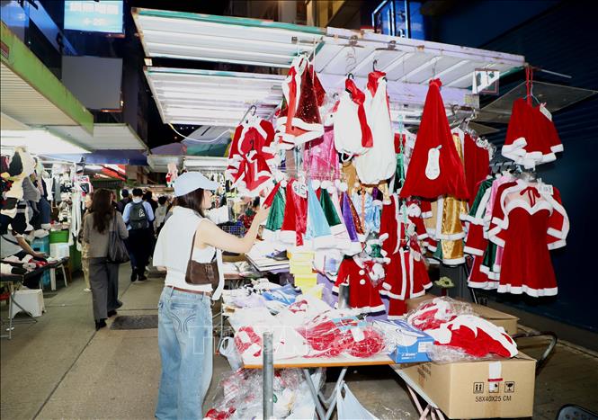 Du khách chọn mua đồ giáng sinh trên đường phố Hong Kong. Ảnh: Xuân Vịnh-Phóng viên TTXVN tại Hong Kong. 