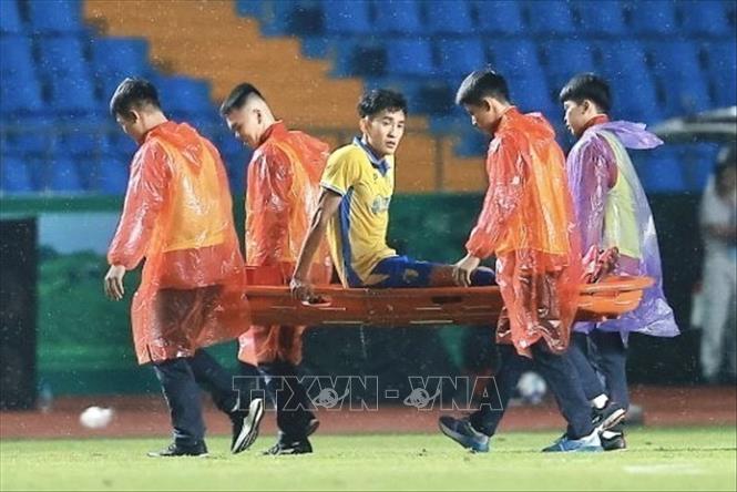 Lê Xuân Tú (số 25, Hà Nội) phải rời sân bằng cáng. Ảnh: Minh Quyết - TTXVN