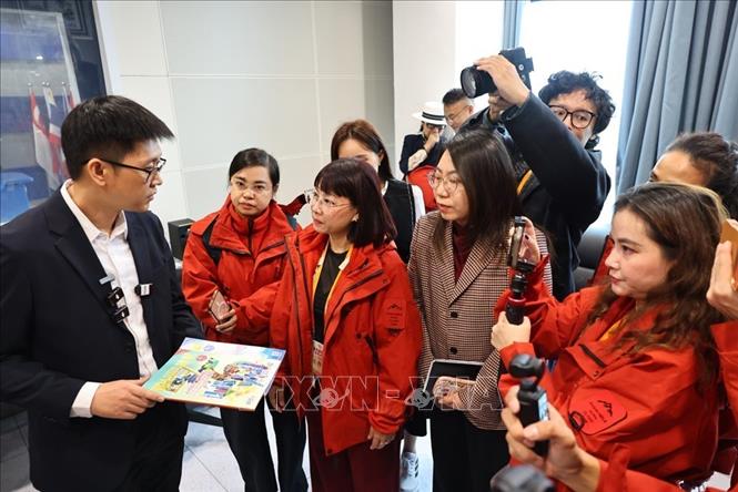 Các đại biểu đến từ các cơ quan Thông tấn, báo chí Việt Nam phỏng vấn lãnh đạo Đài Phát thanh và Truyền hình Quảng Tây (Trung Quốc). Ảnh: Minh Đức - TTXVN