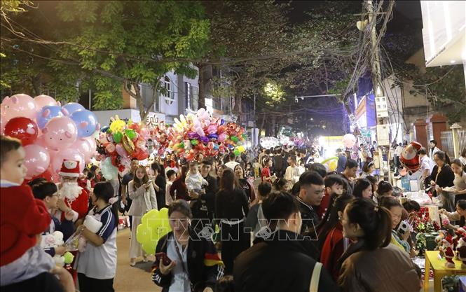 Từ Nhà thờ Vĩnh Yên lan tỏa ra các tuyến phố trung tâm, dòng người tấp nập đổ về vui chơi, chụp ảnh, “check-in”, góp phần vẽ nên bức tranh đêm Giáng sinh rực rỡ sắc màu, sinh động và ấm áp. Ảnh: Hoàng Hùng/TTXVN