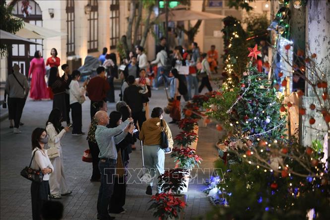 Người dân ghi lại khoảnh khắc trước Giáng sinh 2025 trong khuôn viên Nhà thờ Lớn. Ảnh: Hoàng Hiếu - TTXVN
