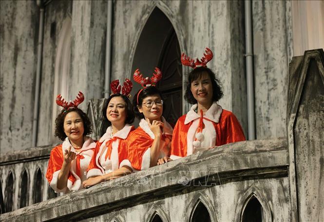 Người dân ghi lại khoảnh khắc trước Giáng sinh 2025 trong khuôn viên Nhà thờ Lớn. Ảnh: Hoàng Hiếu - TTXVN