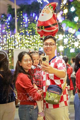 Người dân và du khách đón Giáng sinh tại Nhà thờ Hàm Long, phường Hai Bà Trưng. Ảnh: Khánh Hoà - TTXVN