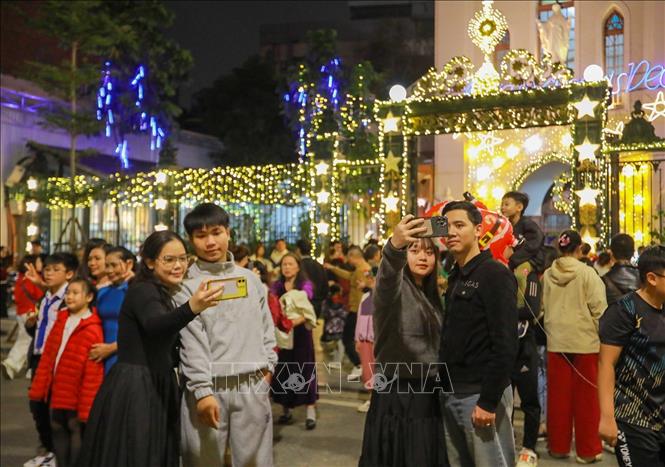 Người dân và du khách đón Giáng sinh tại Nhà thờ Hàm Long, phường Hai Bà Trưng. Ảnh: Khánh Hoà - TTXVN