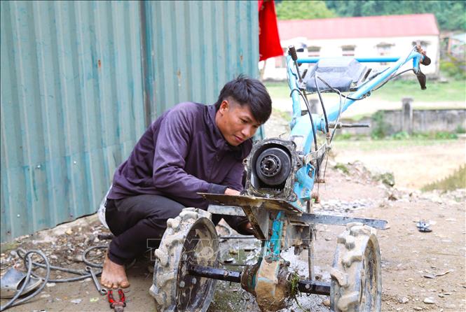 A Dan Lai man exams his machine in preparation for a new crop. VNA Photo: Xuân Tiến
