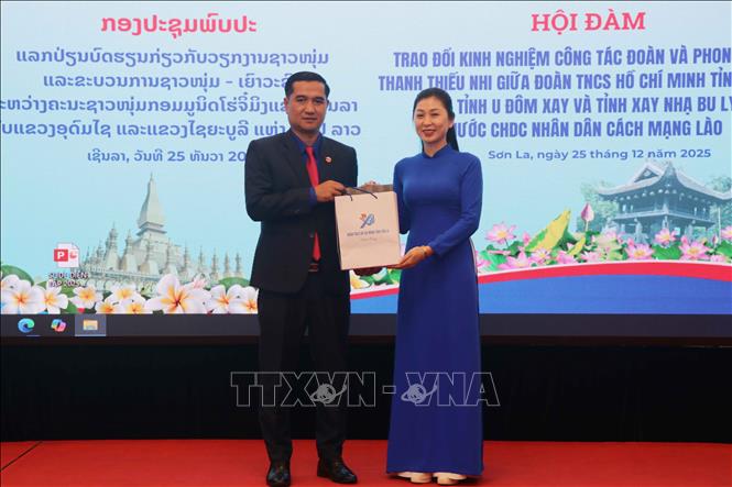 Phó Chủ tịch Ủy ban MTTQ Việt Nam tỉnh, Bí thư Tỉnh đoàn Sơn La Cầm Thị Huyền Trang tặng quà lãnh đạo Đoàn Thanh niên Nhân dân Cách mạng Lào tỉnh U Đôm Xay. Ảnh: Nguyễn Cường - TTXVN.   