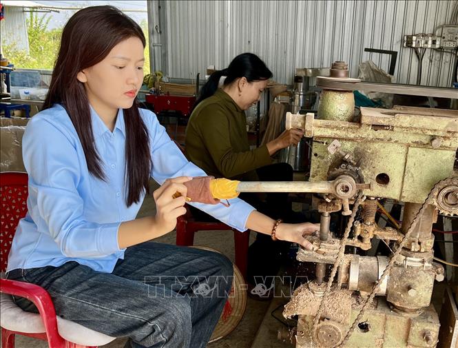 Để làm ra chuỗi hạt đeo tay, đeo cổ từ gỗ thân cây mai trải qua nhiều công đoạn: phơi khô, xẻ, tiện, đánh bóng, lựa hạt đạt chuẩn, xâu chuỗi. Ảnh: Đức Hạnh - TTXVN 