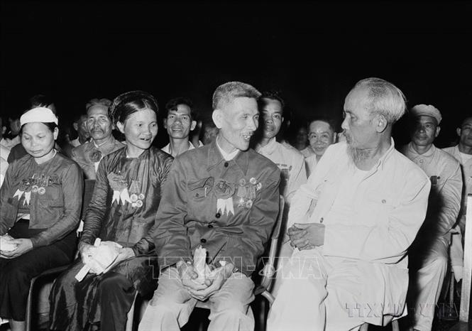 Chủ tịch Hồ Chí Minh nói chuyện thân mật với Anh hùng Lao động Nguyễn Phúc Đồng (ngành Quân giới) và nữ Anh hùng Nguyễn Thị Năm (dệt Nam Định) trong buổi họp mặt các đại biểu dự Đại hội liên hoan Anh hùng, Chiến sĩ thi đua Công-Nông-Binh toàn quốc lần thứ II (Hà Nội, 7/7/1958). Ảnh: TTXVN
