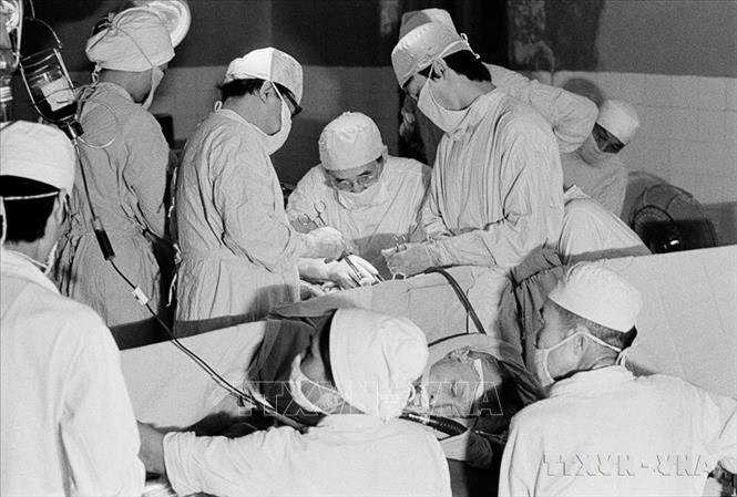 Giáo sư Hoàng Đình Cầu thực hiện phẫu thuật ung thư phổi. Ông là nhà phẫu thuật nổi tiếng, từng thực hiện nhiều ca mổ khó, cứu sống hàng ngàn người bệnh và có hơn 30 công trình nghiên cứu khoa học có giá trị. Ảnh: Thu Hoài-TTXVN
