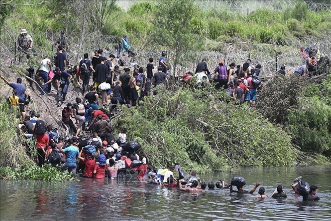 Người di cư từ Ciudad Acuna, Mexico, vượt sông Rio Bravo để tới Mỹ. Ảnh: THX/TTXVN