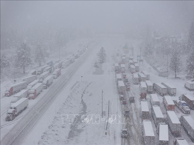 Một cơn bão mùa Đông mạnh đã tràn qua bang California của Mỹ vào ngày 24/12/2025, mang theo mưa lớn và gió giật mạnh, gây sạt lở bùn đất. Trong khi đó, ở phía Bắc bang, mưa lớn và tuyết dày gây điều kiện thời tiết nguy hiểm. Trong ảnh: Tuyết rơi dày đặc khiến giao thông ùn tắc tại California, Mỹ. Ảnh: AA/TTXVN