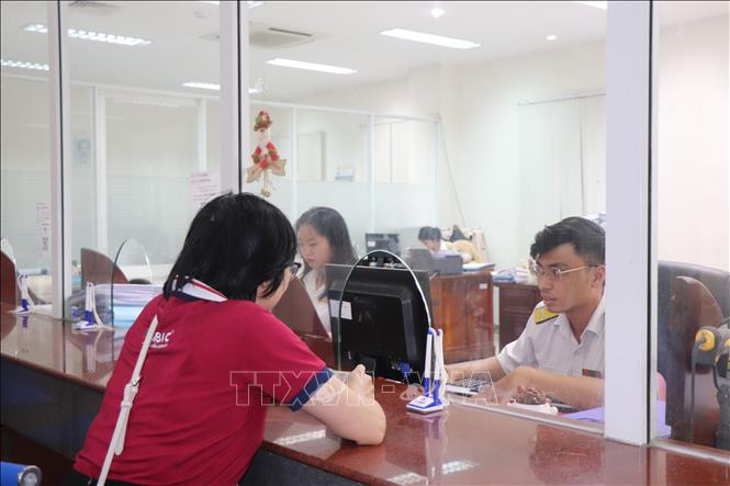 Cán bộ Thuế thành phố Cần Thơ tư vấn, hỗ trợ người nộp thuế. Ảnh: Thu Hiền - TTXVN