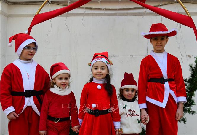 Các em nhỏ mặc trang phục Ông già Noel đón Giáng sinh tại Damascus, Syria. Ảnh: THX/TTXVN