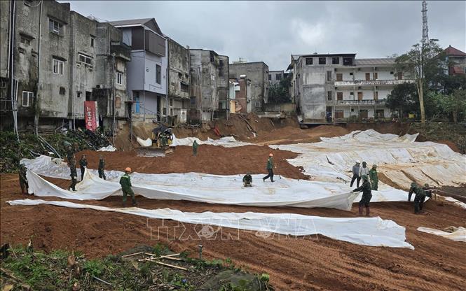 Các lực lượng khẩn trương thi công để hoàn thành công trình khẩn cấp chống sụt trượt tại khu dân cư đường Hùng Vương. Ảnh: TTXVN phát