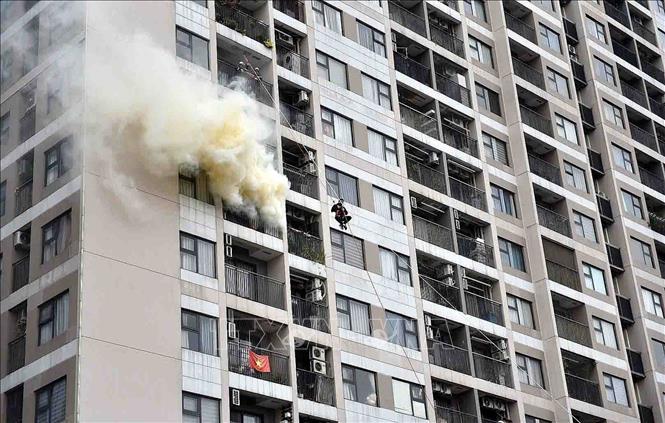 Lực lượng chức năng tập trung rà soát các tầng phía trên khu vực cháy, tìm kiếm người mắc kẹt, đồng thời hướng dẫn thoát nạn có tổ chức tại các tầng phía dưới, triển khai quạt đẩy khói bảo đảm an toàn. Ảnh: TTXVN phát