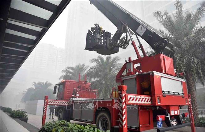 Lực lượng Cảnh sát phòng cháy, chữa cháy và cứu nạn, cứu hộ triển khai đồng bộ nhiều biện pháp cứu người như xe thang, ống tụt, cầu dây nghiêng, cáng cứu thương và mặt nạ lọc độc tại các độ cao khác nhau. Ảnh: TTXVN phát