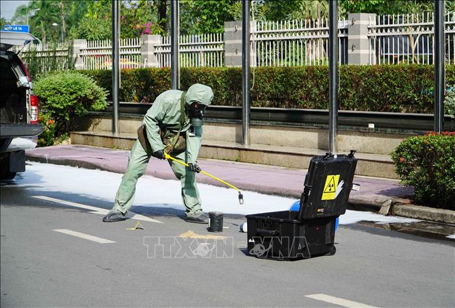 Lực lượng chức năng tiến hành thu hồi nguồn phóng xạ. Ảnh: Thu Hoài - TTXVN