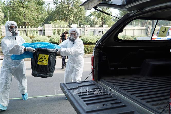 Nguồn phóng xạ, vật thể nhiễm xạ sau khi được thu gom, cô lập được đưa lên xe rời khỏi hiện trường và lưu trữ tạm thời phục vụ điều tra. Ảnh: Thu Hoài - TTXVN