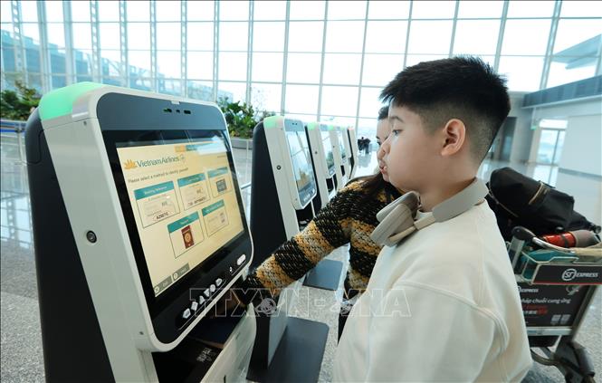 Du khách làm thủ tục check - in tự động chọn chỗ ngồi và nhận thẻ lên máy bay tại sân bay quốc tế Nội Bài những ngày cuối năm 2025. Ảnh: Quốc Khánh - TTXVN