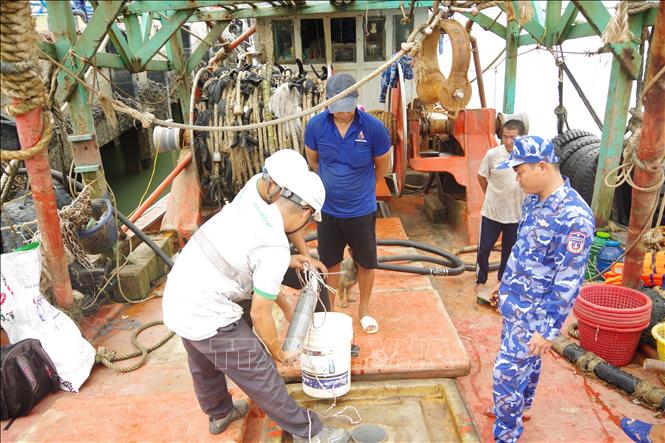 Tổ giám định tiến hành giám định tang vật trên tàu cá KG 8794 TS. Ảnh: TTXVN phát