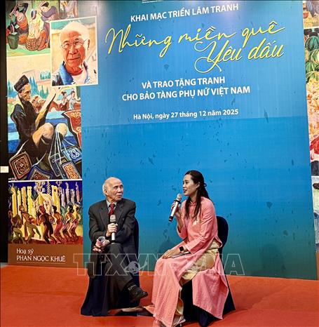 Họa sĩ Phan Ngọc Khuê giao lưu với khán giả tại triển lãm. Ảnh: Phương Lan - TTXVN 