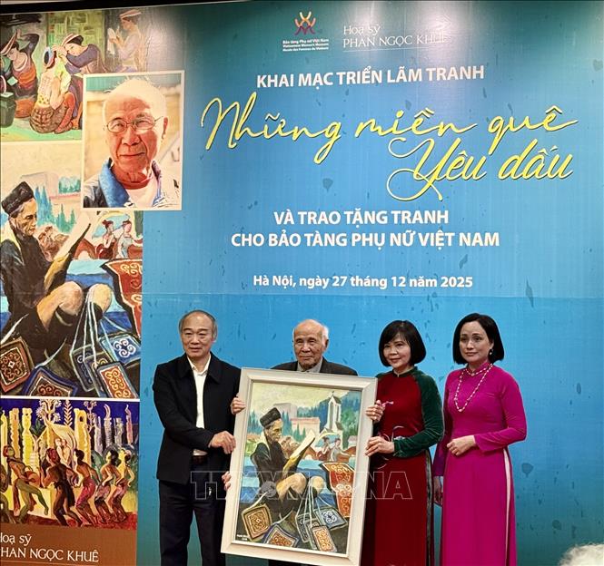 Họa sĩ Phan Ngọc Khuê trao tặng tranh cho Bảo tàng Phụ nữ Việt Nam. Ảnh: Phương Lan - TTXVN 