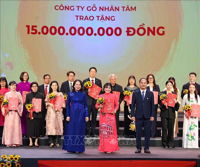Phó Chủ tịch nước, Chủ tịch Hội đồng Bảo trợ Quỹ Bảo trợ trẻ em Việt Nam Võ Thị Ánh Xuân cùng Giám đốc Quỹ Bảo trợ trẻ em Việt Nam Đinh Tiến Hải trao giấy ghi nhận và tặng hoa các nhà tài trợ. Ảnh: Thanh Tùng - TTXVN