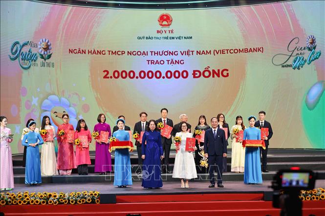 Phó Chủ tịch nước, Chủ tịch Hội đồng Bảo trợ Quỹ Bảo trợ trẻ em Việt Nam Võ Thị Ánh Xuân cùng Giám đốc Quỹ Bảo trợ trẻ em Việt Nam Đinh Tiến Hải trao giấy ghi nhận và tặng hoa các nhà tài trợ. Ảnh: Thanh Tùng - TTXVN