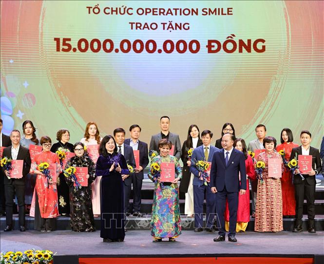 Bộ trưởng Bộ Y tế Đào Hồng Lan cùng Giám đốc Quỹ Bảo trợ trẻ em Việt Nam Đinh Tiến Hải trao giấy ghi nhận và tặng hoa các nhà tài trợ. Ảnh: Thanh Tùng - TTXVN