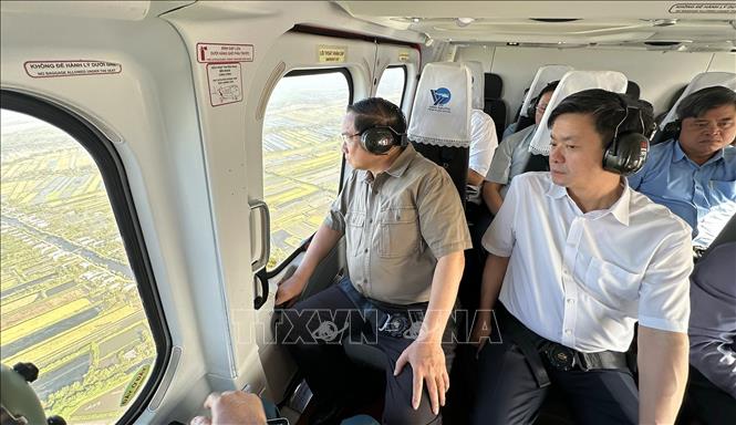 Thủ tướng Phạm Minh Chính thị sát, kiểm tra tuyến đường bộ cao tốc Cà Mau – Đất Mũi, tuyến giao thông ra đảo Hòn Khoai và Cảng tổng hợp lưỡng dụng Hòn Khoai từ trực thăng. Ảnh: Dương Giang-TTXVN
