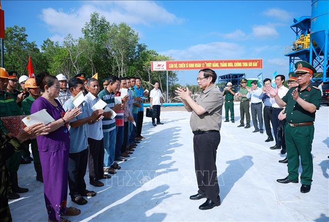 Thủ tướng Phạm Minh Chính tặng quà nhân dân khu vực dự án tuyến đường bộ cao tốc Cà Mau – Đất Mũi, tuyến giao thông ra đảo Hòn Khoai và Cảng tổng hợp lưỡng dụng Hòn Khoai. Ảnh: Dương Giang-TTXVN