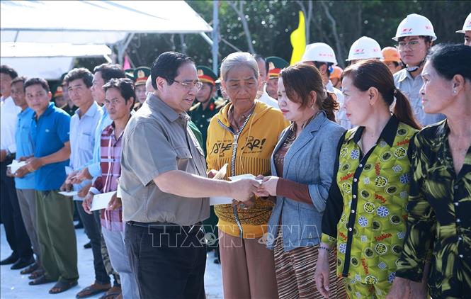 Thủ tướng Phạm Minh Chính tặng quà nhân dân khu vực dự án tuyến đường bộ cao tốc Cà Mau – Đất Mũi, tuyến giao thông ra đảo Hòn Khoai và Cảng tổng hợp lưỡng dụng Hòn Khoai. Ảnh: Dương Giang-TTXVN
