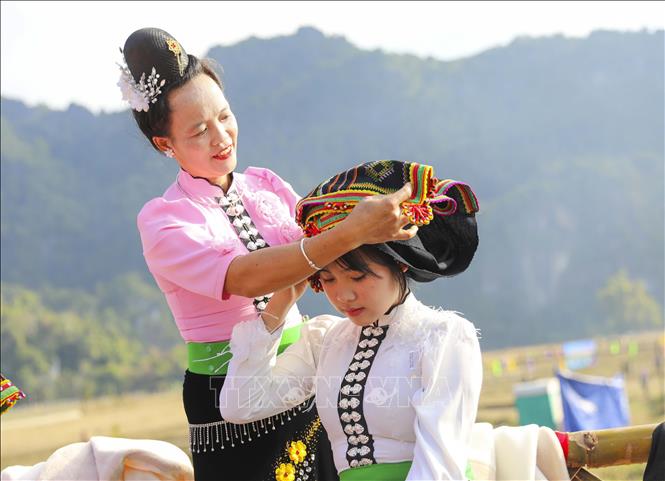 Phụ nữ dân tộc Thái quấn khăn Piêu cho các thiếu nữ. Ảnh: Xuân Tư - TTXVN