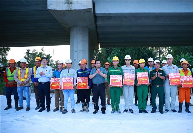 Thủ tướng Phạm Minh Chính tặng quà động viên các kỹ sư, công nhân thi công dự án cao tốc Châu Đốc - Cần Thơ - Sóc Trăng. Ảnh: Dương Giang-TTXVN

