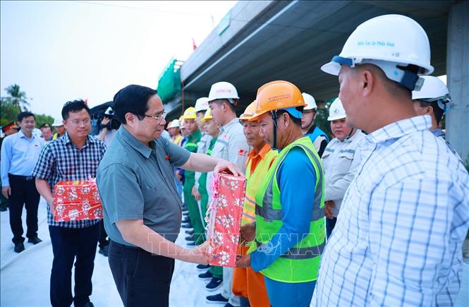 Thủ tướng Phạm Minh Chính tặng quà động viên các kỹ sư, công nhân thi công dự án cao tốc Châu Đốc - Cần Thơ - Sóc Trăng. Ảnh: Dương Giang-TTXVN
