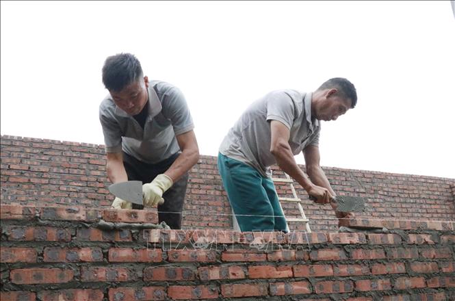 Đẩy nhanh tiến độ xây nhà cho người dân xã Việt Hồng (Lào Cai) để sớm bàn giao trước ngày 10/2/2026. Ảnh: Đinh Thùy - TTXVN