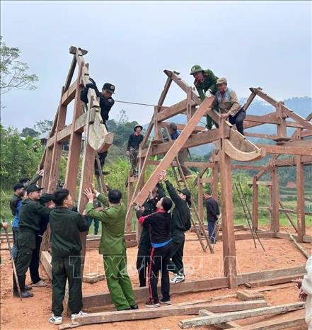 Lực lượng Công an, dân quân hỗ trợ người dân làm nhà ở trước thềm năm mới. Ảnh: TTXVN phát