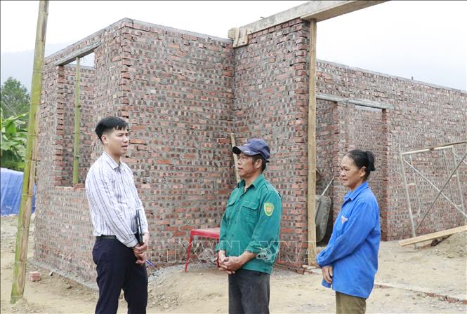 Cán bộ xã Việt Hồng (Lào Cai) kiểm tra tiến độ làm nhà của gia đình ông Hoàng Văn Trưởng. Ảnh: Đinh Thùy - TTXVN