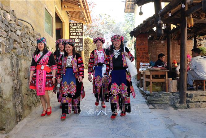 Tourists wear traditional clothes of Lo Lo ethnic group at Lo Lo Chai village. VNA Photo: Đức Thọ