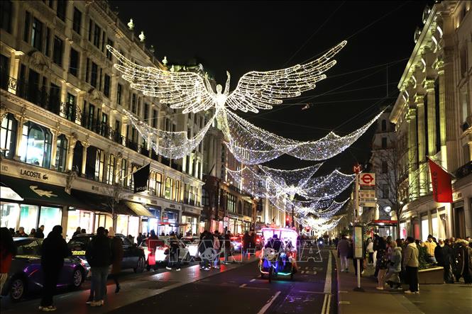 Một chiếc xích lô chăng đèn nhiều màu sắc chở khách tham quan tuyến phố mua sắm Regent street. Ảnh: Hữu Tiến - PV TTXVN tại Anh