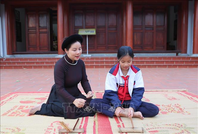 Cô giáo, ca nương Trịnh Thị Hoài Nam hướng dẫn học sinh Vũ Vân Anh, Trường Tiểu học Hòa Bình, gõ phách. Ảnh: Minh Thu- TTXVN