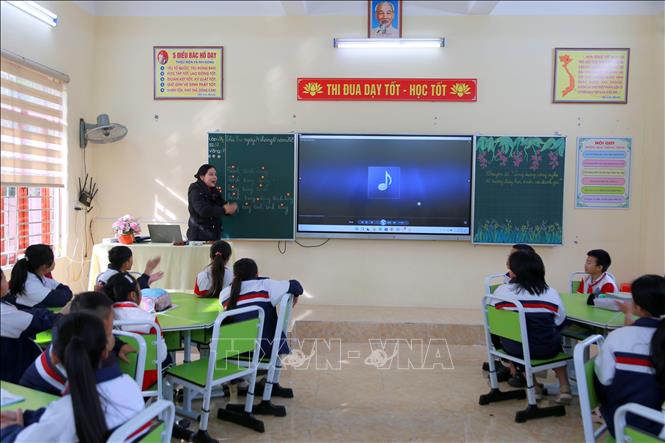 Cô giáo, ca nương Trịnh Thị Hoài Nam, Chủ nhiệm Câu lạc bộ ca trù Trường Tiểu học Hòa Bình, hướng dẫn học sinh tìm hiểu về ca trù. Ảnh: Minh Thu - TTXVN