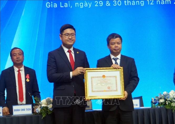 Tặng Bằng khen cá nhân có thành tích xuát sắc trong nhiệm kỳ qua. Ảnh: Trịnh Bang Nhiệm - TTXVN