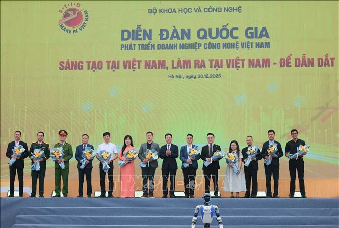 Bộ trưởng Bộ Khoa học và Công nghệ Nguyễn Mạnh Hùng tặng hoa các doanh nghiệp đã có sản phẩm công nghệ tiêu biểu trình diễn tại diễn đàn. Ảnh: Hoàng Hiếu - TTXVN