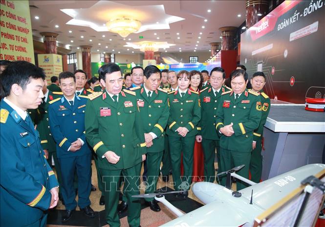 Đại tướng Phan Văn Giang và các đại biểu tham quan khu vực trưng bày các sản phẩm quốc phòng tại đại hội. Ảnh: Trọng Đức - TTXVN