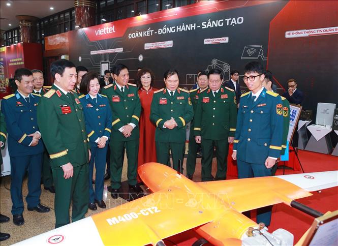 Đại tướng Phan Văn Giang và các đại biểu tham quan khu vực trưng bày các sản phẩm quốc phòng tại đại hội. Ảnh: Trọng Đức - TTXVN